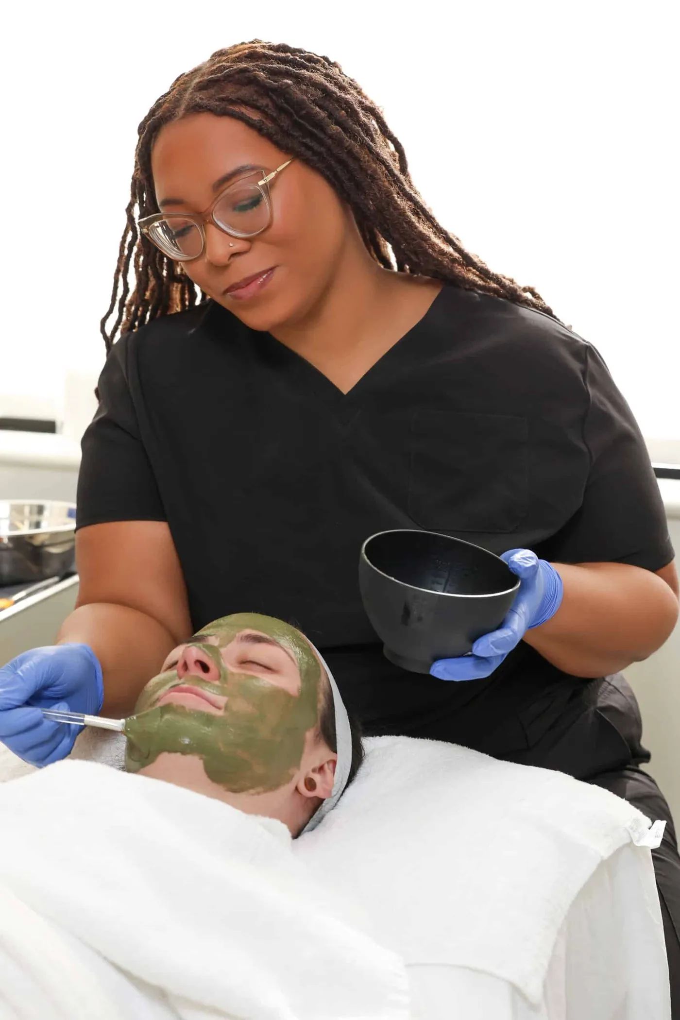A Capital Aesthetic esthetician applying a facial mask